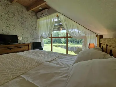 a bedroom with a large bed and a window at Roksala in Taručiai