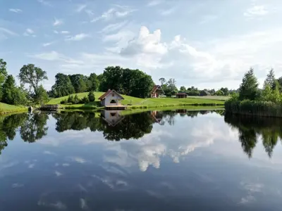 a reflection of a house in a lake at Roksala in Taručiai