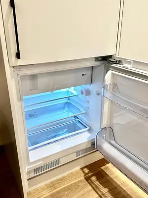 an empty refrigerator with its door open in a kitchen at Brand new studio in the center in Vilnius