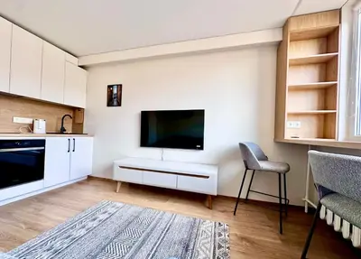 a living room with a flat screen tv on a wall at Brand new studio in the center in Vilnius