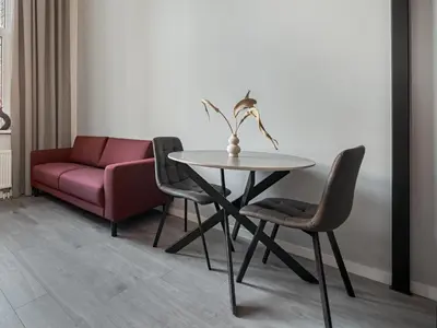a dining room with a table and chairs and a couch at Rusty Red loft in City centre Self check-in No 2 in Vilnius