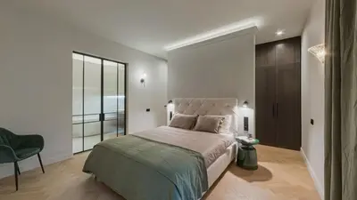 a bedroom with a large bed and a chair at Luxury Courtyard Old-Town Residence in Vilnius