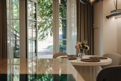 a dining room with a table with a vase of flowers at Luxury Courtyard Old-Town Residence in Vilnius