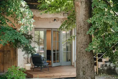 a patio with a chair on a wooden deck at Luxury Courtyard Old-Town Residence in Vilnius