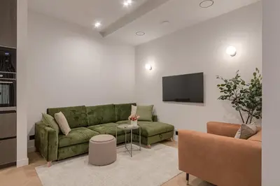 a living room with a green couch and a tv at Luxury Courtyard Old-Town Residence in Vilnius