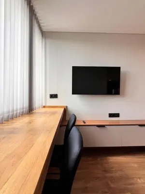 a room with a desk with a television on a wall at Žvėryno studija in Vilnius