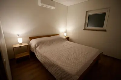 a bedroom with a bed and two night stands with lights at Bijūnų Šilas in Žaugėdai