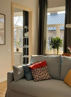 a living room with a gray couch with pillows at Stepono Apartment in Vilnius