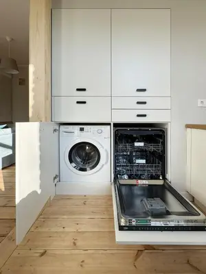 a white kitchen with a dishwasher and a washer at Stepono Apartment in Vilnius