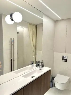 a bathroom with a sink and a toilet and a mirror at M 8 apartment in Kaunas
