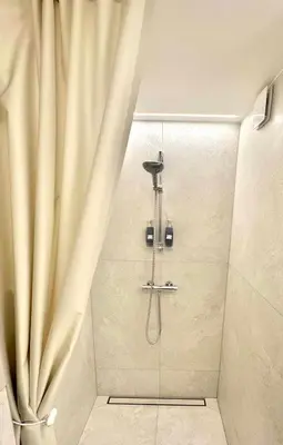 a shower with a shower curtain in a bathroom at M 8 apartment in Kaunas