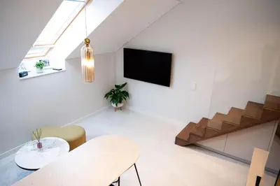 a living room with a table and a tv on the wall at M 8 apartment in Kaunas