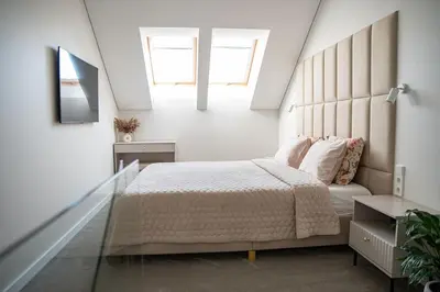 a bedroom with a large bed in a attic at M 8 apartment in Kaunas