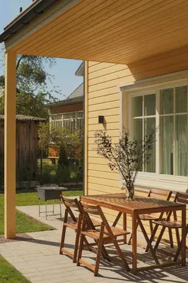 a wooden table and chairs on a patio at Vila 44 in Druskininkai