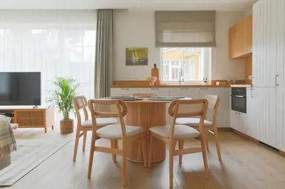 a kitchen with a table and chairs and a kitchen with a tv at Vila 44 in Druskininkai