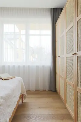 a bedroom with a bed and a large window at Vila 44 in Druskininkai