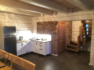 a kitchen with white cabinets and a black refrigerator at Sodyba prie Vidinksto ežero in Pakalniai