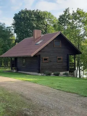 a wooden house with a gambrel roof at Sodyba prie Vidinksto ežero in Pakalniai