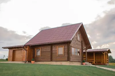 a wooden house with a roof at Sodyba prie Vidinksto ežero in Pakalniai