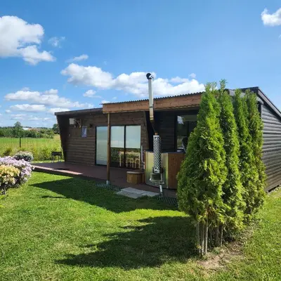 a small house with a garden and a lawn at Vipoilsis Namelis N3 in Čekoniškės
