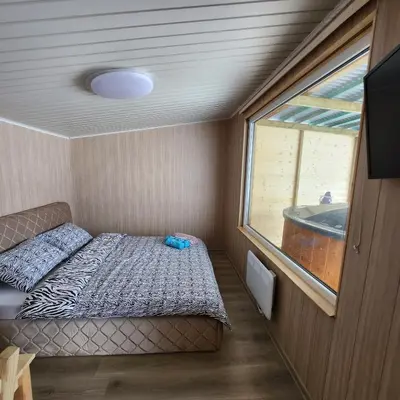 a small room with a bed and a window at Vipoilsis Namelis N3 in Čekoniškės
