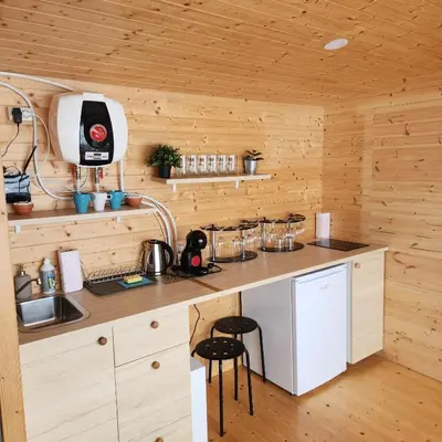 a kitchen with a counter in a wooden cabin at Vipoilsis Namelis N3 in Čekoniškės
