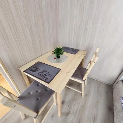 a wooden table with two chairs and a plant on it at Vipoilsis Namelis N3 in Čekoniškės