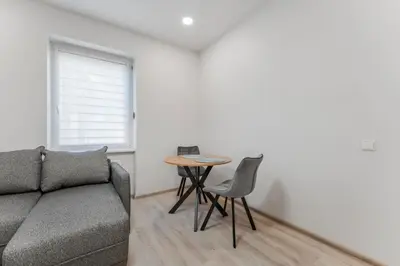 a living room with a couch and a table at Centrinis butas šalia senvagės in Panevėžys