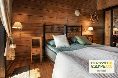 a bedroom with a bed in a wooden room at Countryside Escape - Lake Rooms in Trakai