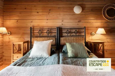 a bedroom with a bed in a wooden wall at Countryside Escape - Lake Rooms in Trakai