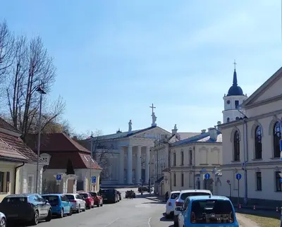 a city street with cars parked in front of a building at Prime Location Apartment Vilnius in Vilnius