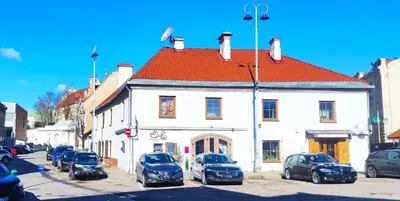 a group of cars parked in front of a white building at Prime Location Apartment Vilnius in Vilnius