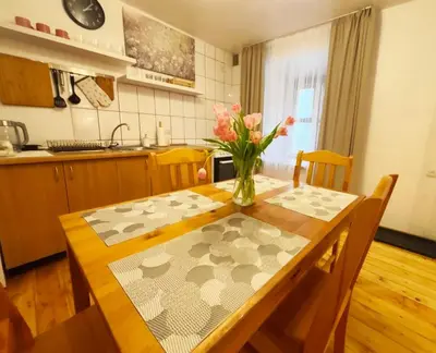 a kitchen with a table with a vase of flowers on it at Prime Location Apartment Vilnius in Vilnius