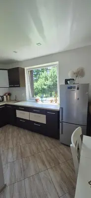 a kitchen with a refrigerator and a window at Stonaičių sodybos Namelis in Kelmė