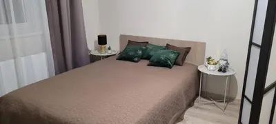 a bedroom with a large bed with green pillows at Stonaičių sodybos Namelis in Kelmė