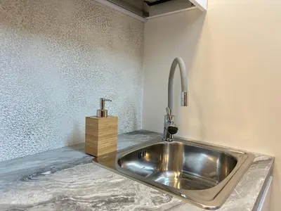 a silver sink in a room with a counter at Feel Comfy Apartment in Druskininkai