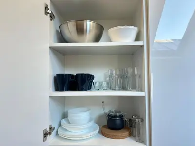a cupboard with plates and bowls and other dishes at Feel Comfy Apartment in Druskininkai