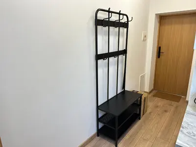a black shelf against a wall next to a door at Feel Comfy Apartment in Druskininkai