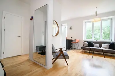 a living room with a mirror and a couch at Charming flat with Great Location by URBAN RENT in Vilnius