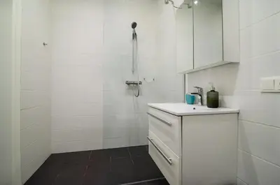 a white bathroom with a sink and a shower at Charming flat with Great Location by URBAN RENT in Vilnius
