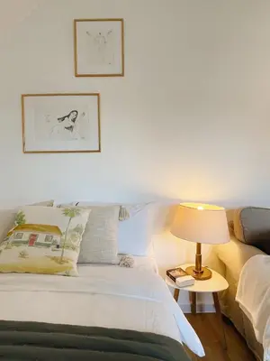 a bedroom with a bed and a table with a lamp at Private, Cozy Home in Kaunas