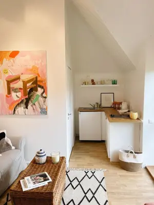 a living room with a table and a kitchen at Private, Cozy Home in Kaunas