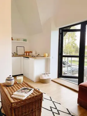 a living room with a table and a kitchen at Private, Cozy Home in Kaunas