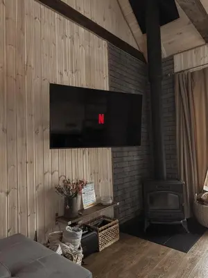 a living room with a flat screen tv on the wall at Bonanza Terra in Rukliai