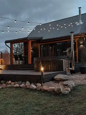 a house with a deck with a fire pit at Bonanza Terra in Rukliai