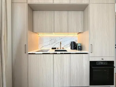 a kitchen with white cabinets and a stove at Žaliakalnis Luxury Suites in Kaunas