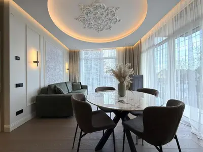 a living room with a glass table and chairs at Žaliakalnis Luxury Suites in Kaunas