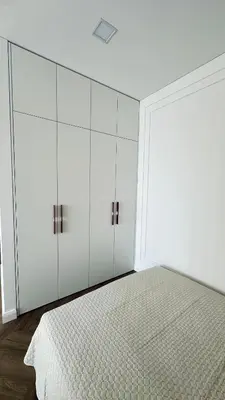 a white bedroom with a bed and white cabinets at Šviesus ir šiltas butas Šiaulių miesto centre in Šiauliai