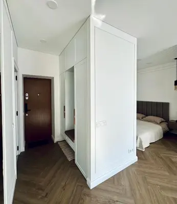 a room with a bed and a large white cabinet at Šviesus ir šiltas butas Šiaulių miesto centre in Šiauliai