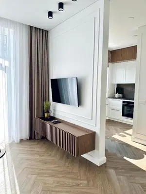 a living room with a flat screen tv on a wall at Šviesus ir šiltas butas Šiaulių miesto centre in Šiauliai